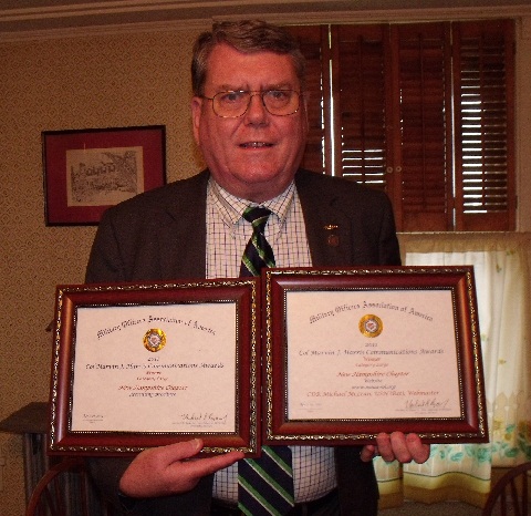 CDR McLean with award certificates
